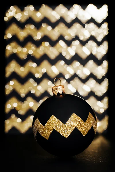 Bola de Natal com um sinal no fundo de ouro brilho — Fotografia de Stock