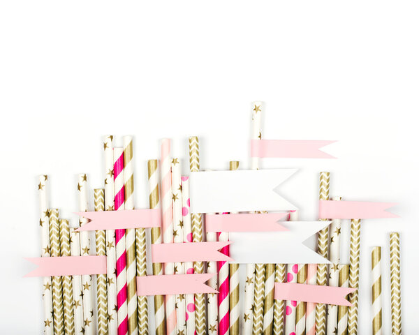 Striped mixed gold and pink paper straws with a sticker on white background