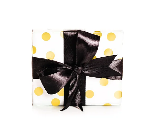 Caja de regalo de lunares dorados y blancos con lazo negro —  Fotos de Stock