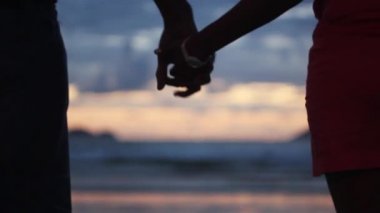 Gün batımında el ele tutuşan çift