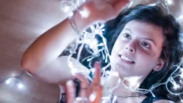 Girl plays with the Christmas lights — Stock Video