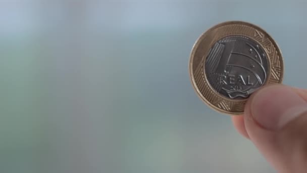 Muchas monedas brasileñas esparcidas sobre la mesa — Vídeo de stock