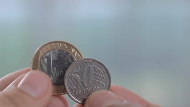 Viele brasilianische Münzen auf dem Tisch verstreut — Stockvideo