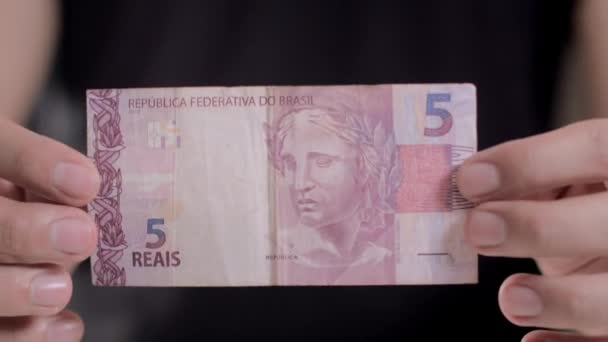 A man shows a note in the amount of 5 reais — Stock Video