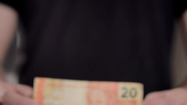 Un uomo mostra una nota per un totale di 20 reais — Video Stock