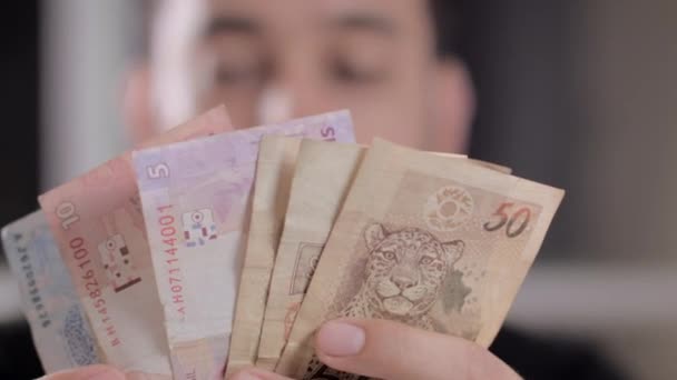 Een man graven geld om huishoudelijke rekeningen te betalen — Stockvideo