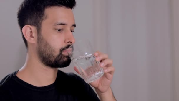 A man takes a bit of water to cool off and hydrate — Stock Video