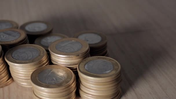 Muchas monedas brasileñas esparcidas sobre la mesa — Vídeos de Stock