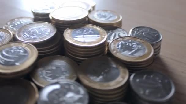 Muchas monedas brasileñas esparcidas sobre la mesa — Vídeos de Stock