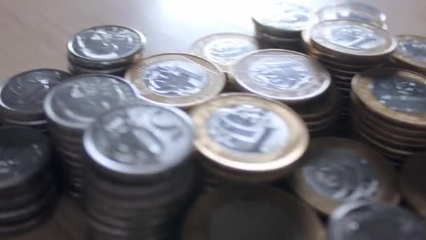 Muchas monedas brasileñas esparcidas sobre la mesa — Vídeos de Stock