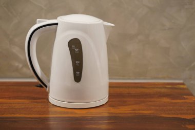 Yan görünüm siyah ve beyaz otomatik sıcak elektrik hava kaplarını tahta zemine, beton duvar arka planına, teknolojiye, elektronik pankarta, kopyalama alanına yerleştirin                                  