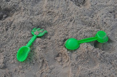 Eski plastik, iki yeşil kum küreği, iki tip, plaja yerleştirilmiş, nesne, dekor, moda, eğlence, komik, çocuk, kopyalama alanı