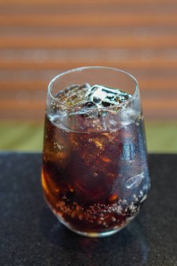 En üstteki soğuk içecek, buz, temiz bir bardakta, siyah mermer bir masaya yerleştirilmiş, kahverengi ahşap duvar arka planı, içecek, serin, taze, nesne, kopyalama alanı