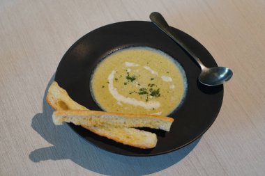 Brokoli ve sebze çorbası siyah bir seramik kasede, iki parça ekmek üzerinde, ve gümüş bir kaşık, ahşap zemin zemin zemin, yiyecek, sebze, nesne, dekor, moda, kopyalama alanı