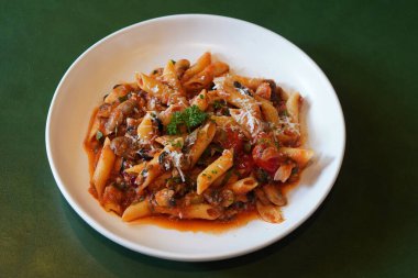 Beyaz seramik tabakta domates sosu, mantar, peynir ve sebze, deri yeşil arka plan, yiyecek, sağlık, fotokopi alanı...