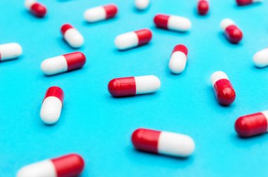 Tıbbi geçmiş olarak mavi üzerine kırmızı-beyaz haplar. Kapat..