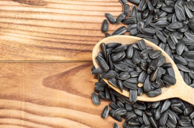 Tahta masada ayçiçeği tohumlu tahta kaşık. Metin için boşluk.