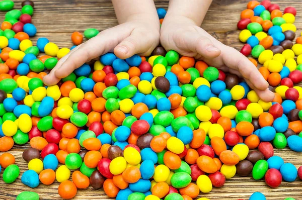 Manos Niño Jugando Con Dulces Caramelos Redondos Mesa Madera — Foto de Stock