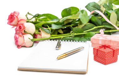 Boş not defteriyle bir demet gül ve beyaz üzerine hediye kutuları.. 