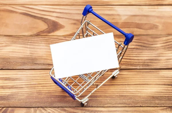 Carro Compras Con Tarjeta Visita Blanco Sobre Mesa Vista Superior — Foto de Stock