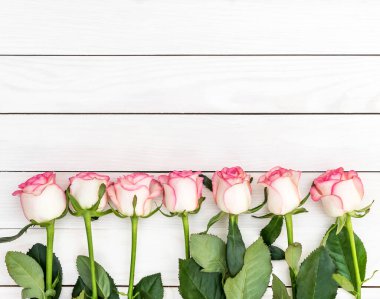 Beyaz ahşap masada güzel güller. Üst Manzara. Metin için boşluk.