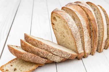 Beyaz ahşap masada kesilmiş bir sıra ekmek.. 