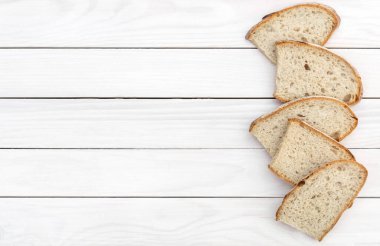 Beyaz ahşap arka planda bir parça ekmek. Üst Manzara. Metin için boşluk.