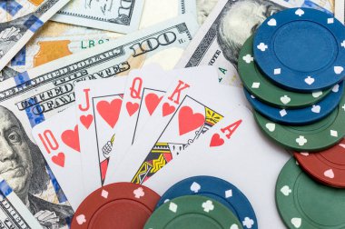 Poker chips and playing card on background of dollar bills.