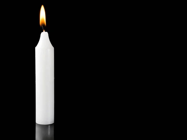Burning candle on black background with space for text.