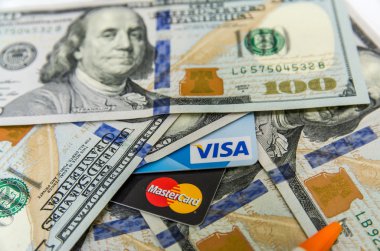 Ternopil, Ukrayna - 05 Ekim 2015: Fotoğraf Visa ve Mastercard kredi kartı ile ABD dolar faturaları