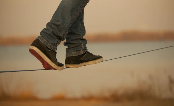 Homem caminhando em slackline — Fotografia de Stock