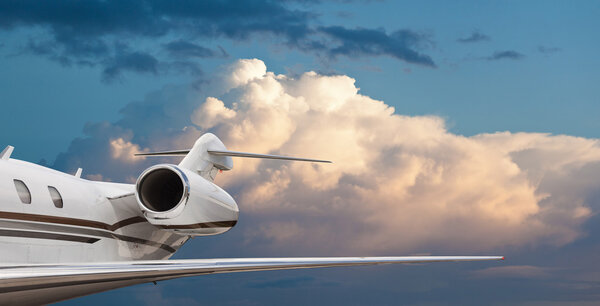 Close tail side view of a private jet flying