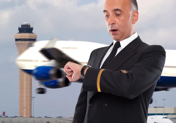 Красивий працівник авіакомпанії дивиться на його годинник — стокове фото