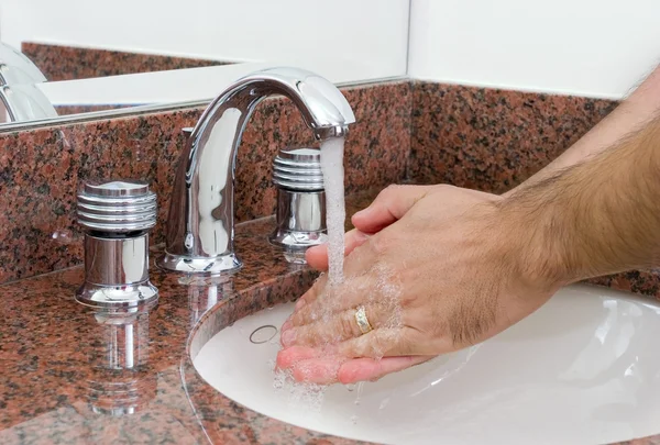 Homme se lavant les mains sous l'eau courante — Photo