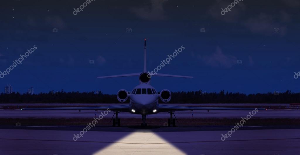 Front view of a private jet on the runway at night Stock Photo by