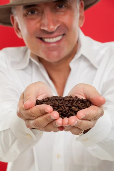 Красивий чоловік тримає кавові зерна на руках — стокове фото