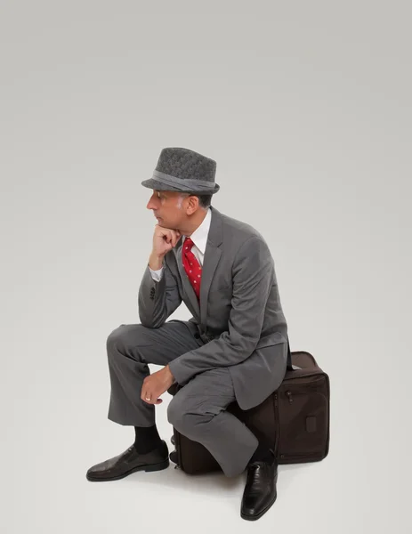 Bir iş Gezgin bekleyen oturma bir bavul üzerinde — Stok fotoğraf