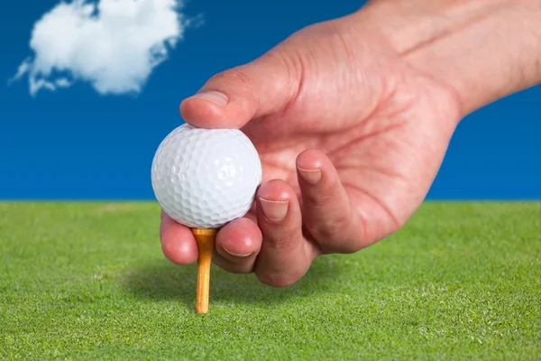 Golfer places a golf ball and tee in the ground — Stock Photo, Image