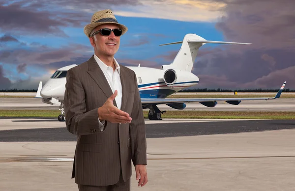 Elegante hombre dando la bienvenida en el aeropuerto junto a un jet privado — Foto de Stock