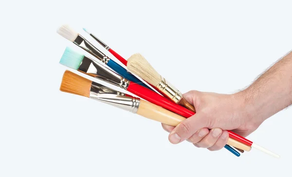 Hand holding several brushes and paint — Stock Photo, Image