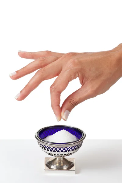 Hand grabbing a pinch of salt — Stock Photo, Image