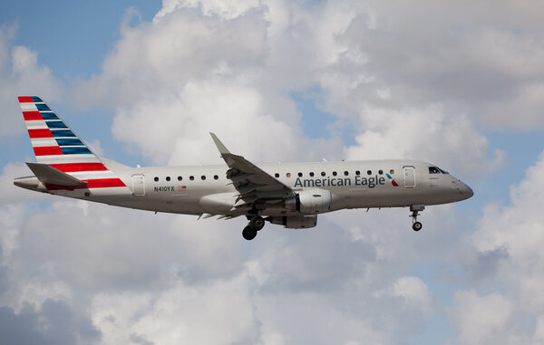 МИАМИ, США - 1 ноября 2015 года: Embraer 175 American Eagle Airlines приземляется в международном аэропорту Майами. American Eagle Airlines является региональным партнером American Airlines
.