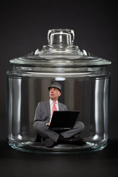 Бізнесмен у пастці всередині прозорої скляної банки — стокове фото