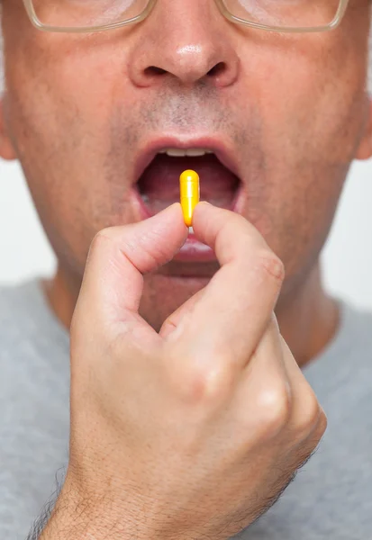 Close up of hand holding a pill — Stock Photo, Image