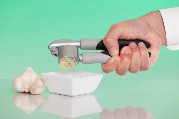 Person using a garlic press — Stock Photo, Image