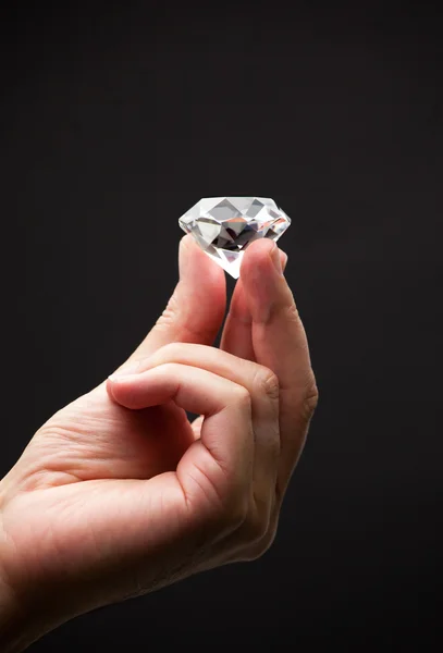 Nahaufnahme einer Hand, die einen Diamanten hält — Stockfoto