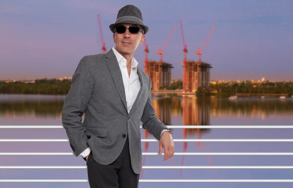 Eleganter Mann posiert vor Baustelle — Stockfoto