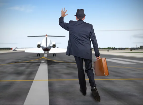飛行機の背後に実行しているビジネスの男性 — ストック写真