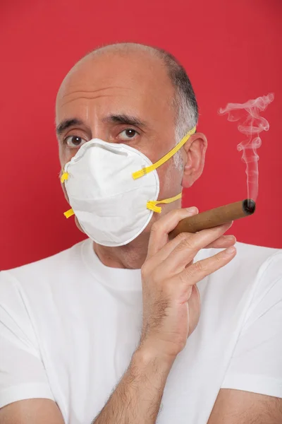 Man smoking a cigar wearing a mask — Stock Photo, Image