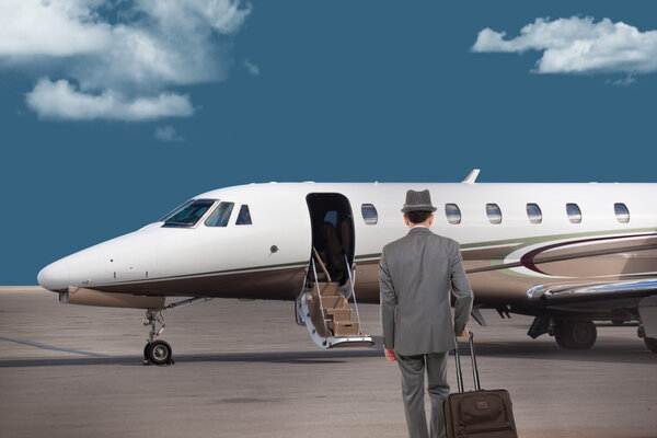 Business man walking toward a private jet
